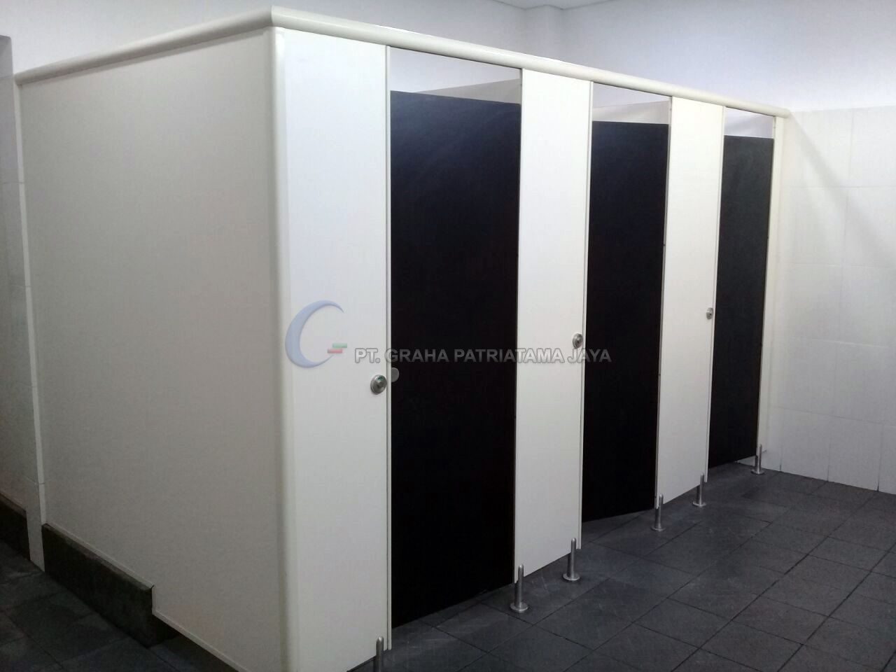 Partisi toilet cubicle putih dengan pintu gelap